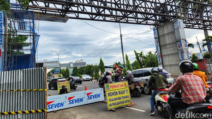 Seorang petugas memberikan arahan kepada pengendara agar jalanan tidak tersendat akibat proyek tersebut.