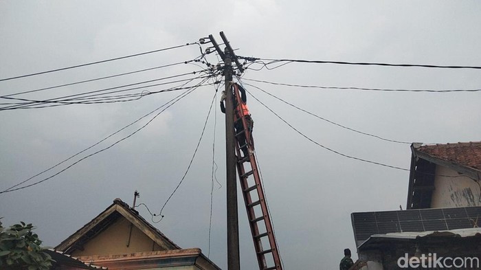 Petugas PLN terlihat mulai memperbaiki jaringan listrik yang sempat diterpa puting beliung di Dusun Mlaten, Sidokepung, Buduran, Sidoarjo