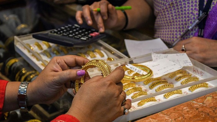 Potret Perayaan Diwali, Warga India Borong Emas MUMBAI, MAHARASHTRA, INDIA - 2022/10/22: A customer holds a pair of gold bangles in her hands at a jewellery shop. Dhanteras marks the first day of Diwali celebration. Hindus worship goddess Laxmi and shop for gold jewellery as it is believed to be sign of good fortune to shop for gold on Dhanteras. (Photo by Ashish Vaishnav/SOPA Images/LightRocket via Getty Images)