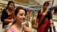 Seorang calon pembeli mencoba perhiasan di salah satu toko perhiasan di India. Sonu Mehta/Hindustan Times/Getty Images