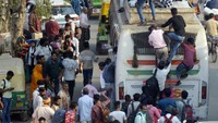 Ribuan warga India berebut naik bus untuk sampai ke kampung halaman. (Sakib Ali/Getty Images)