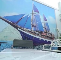 Gambar kapal pinisi khas suku Bugis tampak menghiasi salah satu sudut tembok di halaman belakang. Keluarga gue asli Makassar dan 70 persen karyawan di sini orang Makassar. Jadi orang dari kampung ditarik bokap gue untuk kerja di sini, katanya. (Foto: YouTube/Trans7 Official)