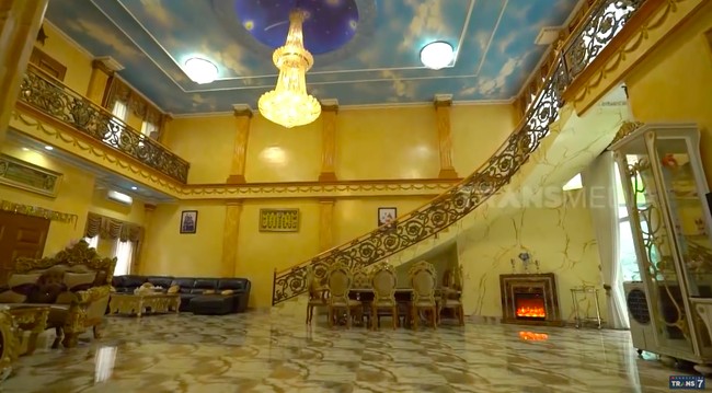 Begini megahnya area tengah rumah keluarga Alam Nur, lengkap dengan lampu kristal yang menggantung dari langit-langit. Menariknya, rumah ini dilengkapi sebuah perapian yang menyala dari layar. (Foto: YouTube/Trans7 Official)