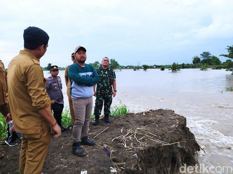 Rumah warga Gresik tergenang banjir. Bupati Gresik cek kondisi tanggul yang jebol.