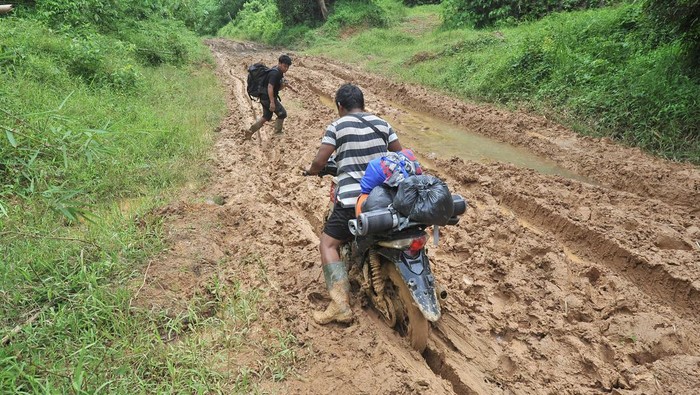 Warga Suku Talang Mamak mengendarai sepeda motor melintasi jalan rusak di Dusun Semerantihan, Sumay, Tebo, Jambi, Minggu (23/10/2022). Semerantihan yang merupakan penyangga Taman Nasional Bukit Tigapuluh yang dihuni sekitar 50 kepala keluarga (KK) Suku Talang Mamak berjarak sekitar 36 kilometer dari pusat pemerintahan desa dengan akses jalan yang rusak dan membutuhkan perhatian pemerintah. ANTARA FOTO/Wahdi Septiawan/foc.