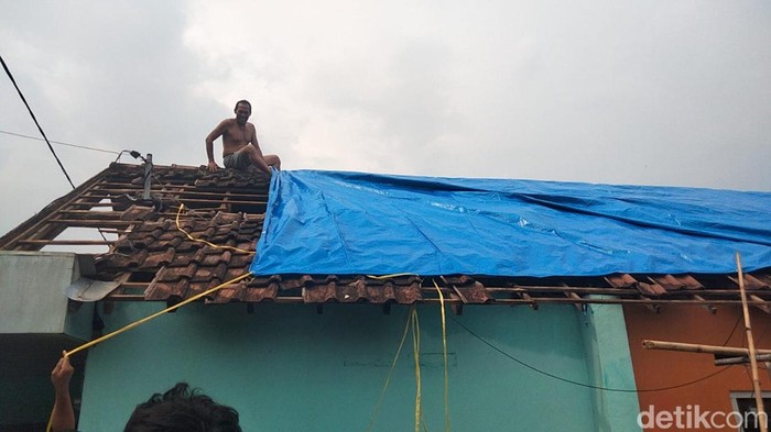 Warga Dusun Mlaten terdampak puting beliung membeli dan memasang terpal sendiri untuk menutupi atap rumah