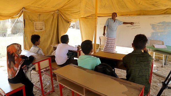 HAJJAH, YEMEN - OCTOBER 23: Yemeni students are seen at the Yermuk school, built by teachers, students and parents built with their own means in Hajjah, Yemen on October 23, 2022. In Yemen, which was struggling with civil war and political instability, teachers and students build their own schools with limited opportunities to continue their education. Teachers, students and parents built the classrooms consisting of huts and tents by moving the tree branches they cut from miles away to an empty field. The Yermuk school, which consists of 4 wooden barracks and 5 tents, approximately 150 students receive education under difficult conditions. (Photo by Mohammed Al-Wafi/Anadolu Agency via Getty Images)