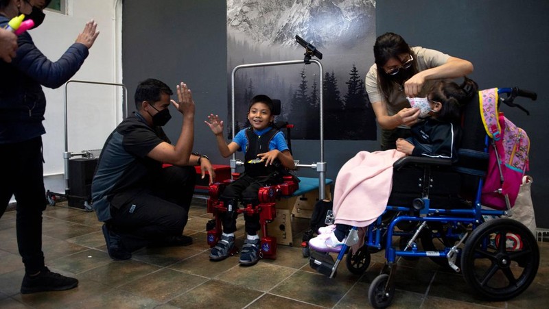 David Zabala (C), an 8-year-old boy with cerebral palsy, is assisted by physical therapists during a rehabilitation session with the robotic exoskeleton Atlas 2030 at the Association for People with Cerebral Palsy (APAC) in Mexico City on October 18, 2022. - The Atlas 2030 pediatric exoskeleton, which won its creator, Spanish Elena García Armada, the 2022 European Inventor award, has been in use in Mexico since October, thanks to the efforts of the Association for People with Cerebral Palsy (APAC), a private organisation founded in 1970. (Photo by CLAUDIO CRUZ / AFP) (Photo by CLAUDIO CRUZ/AFP via Getty Images)
