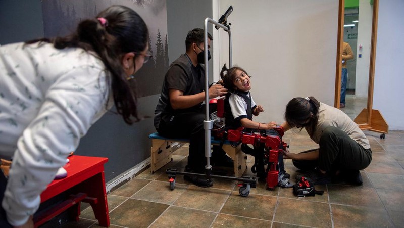 David Zabala (C), an 8-year-old boy with cerebral palsy, is assisted by physical therapists during a rehabilitation session with the robotic exoskeleton Atlas 2030 at the Association for People with Cerebral Palsy (APAC) in Mexico City on October 18, 2022. - The Atlas 2030 pediatric exoskeleton, which won its creator, Spanish Elena García Armada, the 2022 European Inventor award, has been in use in Mexico since October, thanks to the efforts of the Association for People with Cerebral Palsy (APAC), a private organisation founded in 1970. (Photo by CLAUDIO CRUZ / AFP) (Photo by CLAUDIO CRUZ/AFP via Getty Images)
