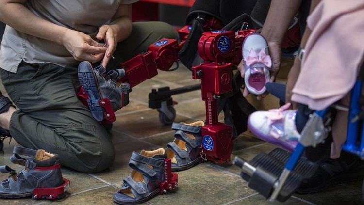 David Zabala (C), an 8-year-old boy with cerebral palsy, is assisted by physical therapists during a rehabilitation session with the robotic exoskeleton Atlas 2030 at the Association for People with Cerebral Palsy (APAC) in Mexico City on October 18, 2022. - The Atlas 2030 pediatric exoskeleton, which won its creator, Spanish Elena García Armada, the 2022 European Inventor award, has been in use in Mexico since October, thanks to the efforts of the Association for People with Cerebral Palsy (APAC), a private organisation founded in 1970. (Photo by CLAUDIO CRUZ / AFP) (Photo by CLAUDIO CRUZ/AFP via Getty Images)