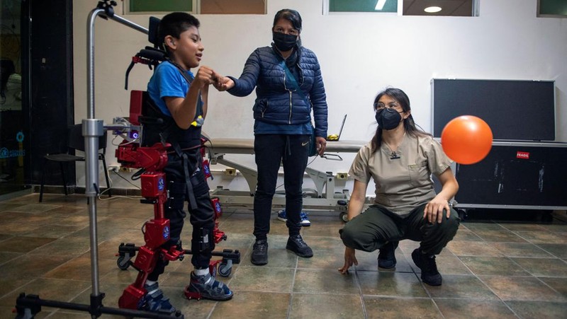 David Zabala (C), an 8-year-old boy with cerebral palsy, is assisted by physical therapists during a rehabilitation session with the robotic exoskeleton Atlas 2030 at the Association for People with Cerebral Palsy (APAC) in Mexico City on October 18, 2022. - The Atlas 2030 pediatric exoskeleton, which won its creator, Spanish Elena García Armada, the 2022 European Inventor award, has been in use in Mexico since October, thanks to the efforts of the Association for People with Cerebral Palsy (APAC), a private organisation founded in 1970. (Photo by CLAUDIO CRUZ / AFP) (Photo by CLAUDIO CRUZ/AFP via Getty Images)