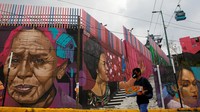 Seorang pemuda melewati mural di lingkungan Iztapalapa di Mexico City, Meksiko, Kamis (20/10/2022).