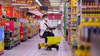 Seorang warga menaiki kendaraan listrik saat berbelanja di supermarket di Xi an, provinsi Shaanxi, China, Senin (24/10/2022).  