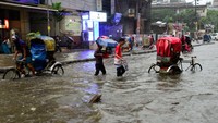 Sejumlah kendaraan bermotor dan becak mencoba menerobos jalan-jalan yang tergenang air di Dhaka, Bangladesh, Senin (24/10/2022). (Syed Mahamudur Rahman/Getty Images)