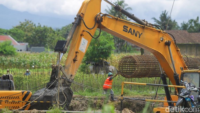 Pekerja terlihat melakukan pengerjaan konstruksi Jalan Tol Yogyakarta-Bawen Seksi 1 menggunakan alat berat di Tirtoadi, Mlati, Sleman, Yogyakarta, Rabu (25/10/2022)
