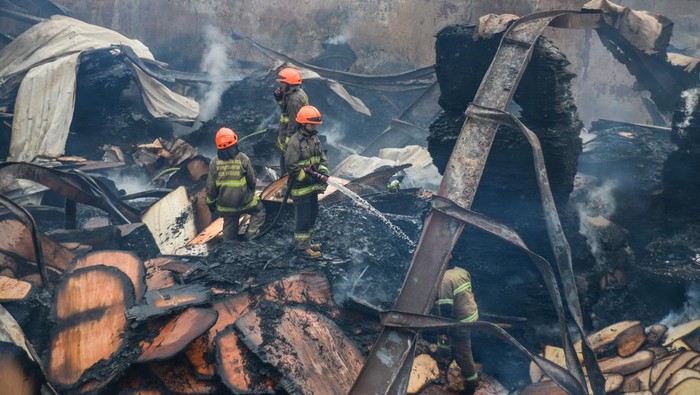 Petugas pemadam kebakaran melakukan pendinginan gudang triplek yang terbakar di Jalan Soekarno-Hatta, Cijagra, Bandung, Jawa Barat, Rabu (26/10/2022). Petugas berhasil memadamkan api yang membakar gudang triplek setelah berjibaku menjinakkan api selama 37 jam. ANTARA FOTO/Raisan Al Farisi/rwa.