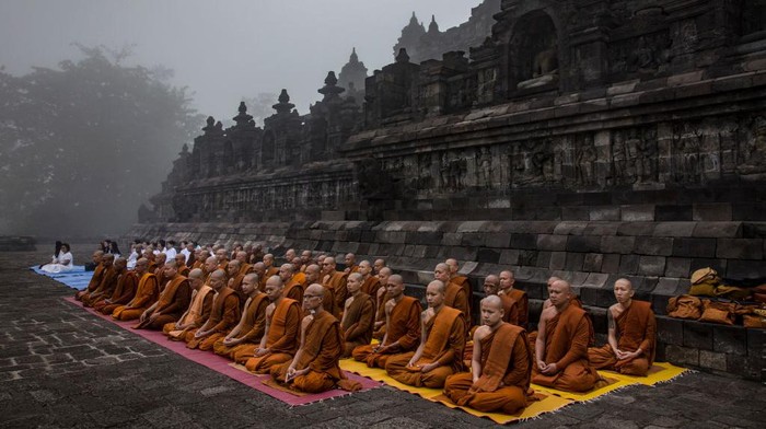 MAGELANG, CENTRAL JAVA, INDONESIA - MAY 18: Buddhist monks pray at Borobudur temple during celebrations for Vesak Day on May 18, 2019 in Magelang, Central Java, Indonesia. Buddhists in Indonesia celebrate Vesak at the Borobudur temple annually, which makes it the most visited tourist attraction in Indonesia. It is observed during the full moon in May or June, with the ceremony centered at three Buddhist temples by walking from Mendut to Pawon and ending at Borobudur. The stages of life of Buddhisms founder, Gautama Buddha, which are celebrated at Vesak are his birth, enlightenment to Nirvana, and his passing (Parinirvana). (Photo by Ulet Ifansasti/Getty Images)