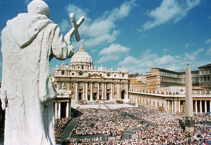 (Original Caption) A 17th century statue of an early Christian saint looks down from atop the famed Bernini colonnade surrounding St. Peters Square. As in years past, crowd will throng to the plaza for the annual Easter message of Pope Paul VI from the balcony over the main door of St. Peters Basilica. At right, background, are the Papal apartments and seat of the Roman Catholic Church government.