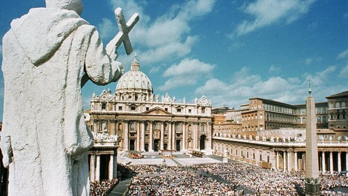 (Original Caption) A 17th century statue of an early Christian saint looks down from atop the famed Bernini colonnade surrounding St. Peters Square. As in years past, crowd will throng to the plaza for the annual Easter message of Pope Paul VI from the balcony over the main door of St. Peters Basilica. At right, background, are the Papal apartments and seat of the Roman Catholic Church government.