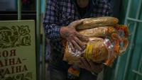 Relawan membagikan jatah roti kepada warga sipil di sebuah sekolah umum di Mykolaiv.