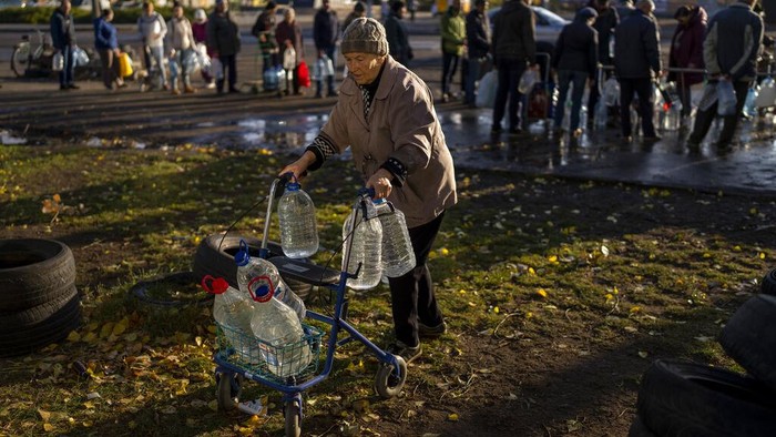 Antrean Panjang Warga Mykolaiv Ukraina Demi Minum dan Makan People queue to receive a daily ration of bread in a school in Mykolaiv, Tuesday, Oct. 25, 2022. Mykolaiv residents pick up bread from the only food distribution point in Varvarivka, a Mykolaiv district where thousands of people live. One person is allowed to receive free bread just once in three days. (AP Photo/Emilio Morenatti)