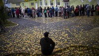 Penduduk Mykolaiv mengambil roti dari satu-satunya titik distribusi makanan di Varvarivka, sebuah distrik Mykolaiv tempat ribuan orang tinggal. Satu orang diperbolehkan menerima roti gratis hanya sekali dalam tiga hari.