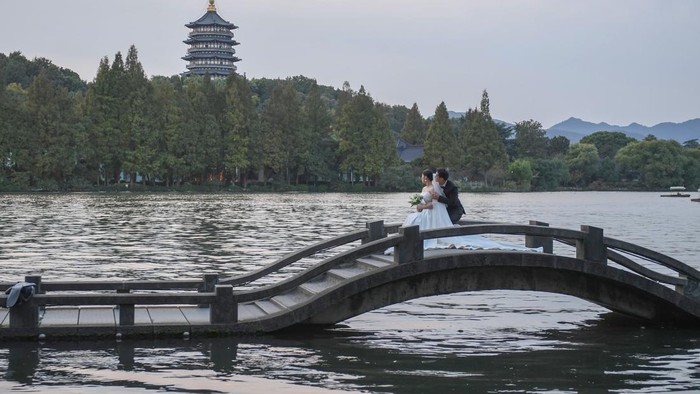 Danau di China Jadi Spot Favorit Foto Pre-Wedding HANGZHOU, CHINA - OCTOBER 25: Couples pose for pre-wedding pictures at West Lake on October 25, 2022 in Hangzhou, Zhejiang Province of China. (Photo by Wang Gang/China News Service via Getty Images)