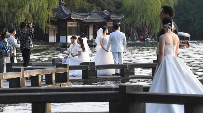 HANGZHOU, CHINA - OCTOBER 25: Couples pose for pre-wedding pictures at West Lake on October 25, 2022 in Hangzhou, Zhejiang Province of China. (Photo by Wang Gang/China News Service via Getty Images)