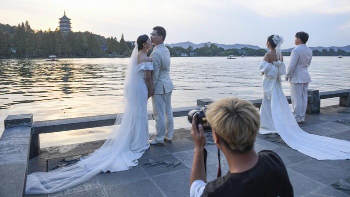 Danau di China Jadi Spot Favorit Foto Pre-Wedding HANGZHOU, CHINA - OCTOBER 25: Couples pose for pre-wedding pictures at West Lake on October 25, 2022 in Hangzhou, Zhejiang Province of China. (Photo by Wang Gang/China News Service via Getty Images)