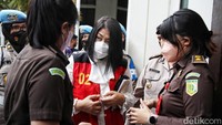 Petugas kejaksaan melepas rompi tahanan Putri Candrawathi sebelum memasuki ruang sidang. Borgol di tangan Putri juga dilepas.