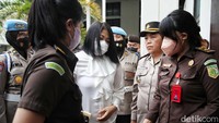 Dengan mengenakan pakaian serba putih, Putri memasuki ruang sidang PN Jaksel. 