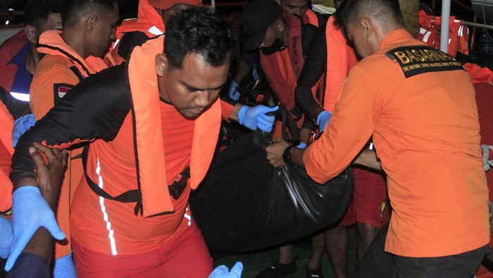 Tim SAR mengevakuasi kantong berisi jenazah korban terbakarnya kapal cepat Cantika Express 77 di Dermaga Tenau, Kupang, NTT, Selasa (25/10/2022) malam. Tim SAR menemukan lagi tiga jenazah hingga jumlah korban meninggal bertambah dari 14 menjadi 17 jiwa.