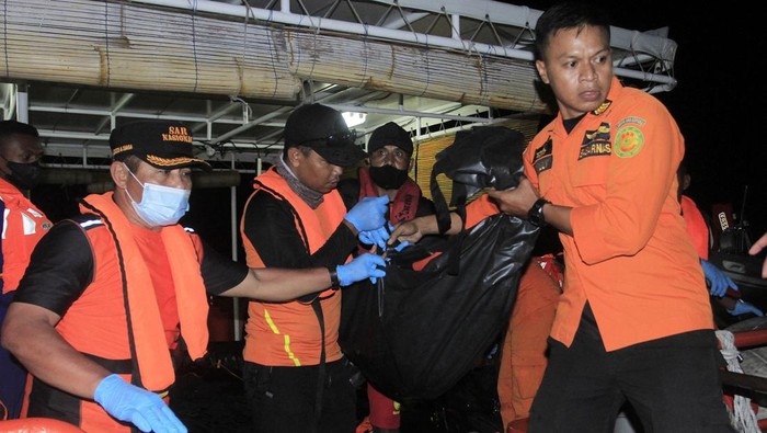 Tim SAR mengevakuasi kantong berisi jenazah korban terbakarnya kapal cepat Cantika Express 77 di Dermaga Tenau, Kupang, NTT, Selasa (25/10/2022) malam. Tim SAR menemukan lagi tiga jenazah hingga jumlah korban meninggal bertambah dari 14 menjadi 17 jiwa.