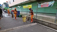 Petugas kebersihan terlihat sedang melakukan pembersihan di bawah lokasi kaca gedung. 