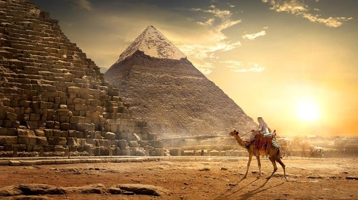 Nomad on camel near pyramids in egyptian desert