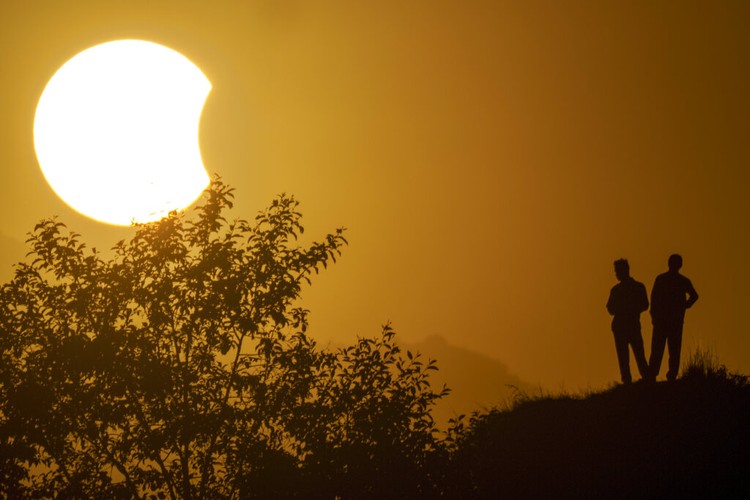 The moon blocks part of the sun during a partial solar eclipse in downtown Beirut, Lebanon, Tuesday, Oct. 25, 2022. (AP Photo/Hassan Ammar)