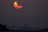 The moon blocks part of the sun during a partial solar eclipse in downtown Beirut, Lebanon, Tuesday, Oct. 25, 2022. (AP Photo/Hassan Ammar)