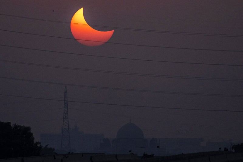 The moon blocks part of the sun during a partial solar eclipse in downtown Beirut, Lebanon, Tuesday, Oct. 25, 2022. (AP Photo/Hassan Ammar)