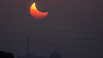 Gerhana Matahari parsial terlihat di atas monumen Makam Humayun di New Delhi, India. Foto: AP/Hassan Ammar