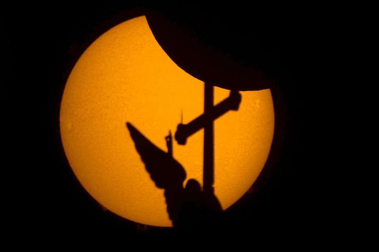 The moon blocks part of the sun during a partial solar eclipse in downtown Beirut, Lebanon, Tuesday, Oct. 25, 2022. (AP Photo/Hassan Ammar)