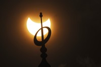 The moon blocks part of the sun during a partial solar eclipse in downtown Beirut, Lebanon, Tuesday, Oct. 25, 2022. (AP Photo/Hassan Ammar)