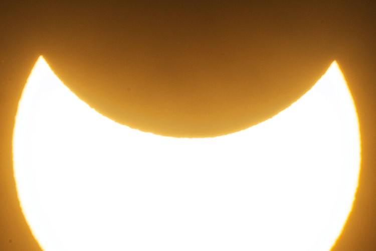 The moon blocks part of the sun during a partial solar eclipse in downtown Beirut, Lebanon, Tuesday, Oct. 25, 2022. (AP Photo/Hassan Ammar)