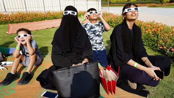 Orang-orang menyaksikan gerhana matahari sebagian menggunakan kacamata khusus di Pusat Astronomi Al Thuraya di Dubai, Uni Emirat Arab, Selasa (25/10/2022). Gerhana matahari sebagian bisa disaksikan oleh warga dengan kacamata khusus. (AP Photo/Kamran Jebreili)  