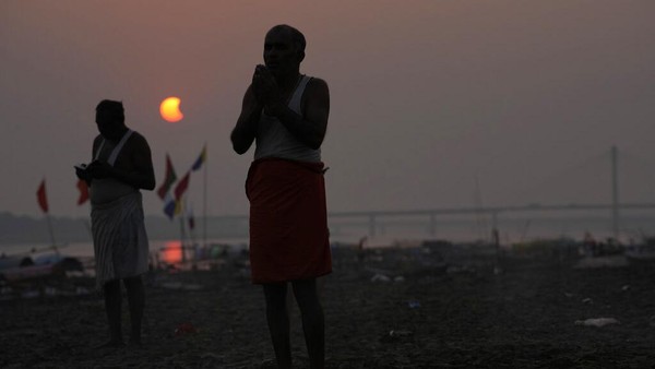 Umat Hindu melakukan ritual di Sangam, selama gerhana matahari sebagian di Prayagraj, negara bagian utara Uttar Pradesh, India, Selasa (25/10/2022). Fenomena gerhana matahari sebagian terjadi pada 25 Oktober 2022 dan bisa dilihat di sejumlah negara. (AP Photo/Rajesh Kumar Singh)  