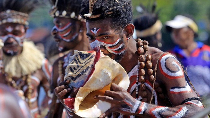 Seorang penari meniup terompet tradisional khas Papua, triton dalam Festival Danau Sentani ke-13 di Pantai Khalkote, Kabupaten Jayapura, Papua, Selasa (25/10/2022). Festival yang digelar hingga 29 Oktober 2022 tersebut menampilkan berbagai kesenian tradisional khas Papua dan hasil kerajinan serta makanan khas Papua buatan masyarakat setempat. ANTARA FOTO/Gusti Tanati/app/foc.