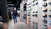 Pengunjung melihat produk sepatu Adidas. Adidas telah bermitra dengan Kanye sejak 2013 untuk bersaing dengan Nike. Tahun 2016, Adidas mempererat hubungannya dengan sang raper, menjadikan Kanye partner bisnis Adidas berpengaruh di luar bidang olahraga.