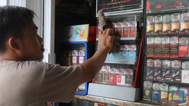 Pedagang menata rokok di warung eceran di Warung Dua Saudara Pejaten, Jakarta, Rabu, (26/10). Naiknya tarif cukai rokok dari waktu ke waktu, membuat sejumlah orang memilih alternatif rokok dengan harga murah. Ghofar pemilik warung eceran menjual berbagai macam Merk rokok mengatakan biasanya orang yang beralih rokok itu karena mencari harga yang lebih murah dengan jenis yang sama. (CNBC Indonesia/ Muhammad Sabki)