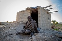 Amou Haji duduk di depan gubuk bata terbuka yang dibangun oleh penduduk desa untuknya, di pinggiran desa Dezhgah di distrik Dehram, provinsi Fars, Iran, Jumat (28/12/2018).