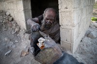 Amou Haji (uncle Haji) smokes from his waterpipe as he sits on the ground on the outskirts of the village of Dezhgah in the Dehram district of the southwestern Iranian Fars province, on December 28, 2018. - Believed to be the worlds dirtiest man, villagers say that Hajis leather-like skin hasnt touched soap and water for more than sixty years. They believe that he decided to live in isolation after suffering from an emotional setback in his youth. (Photo by - / AFP) (Photo by -/AFP via Getty Images)