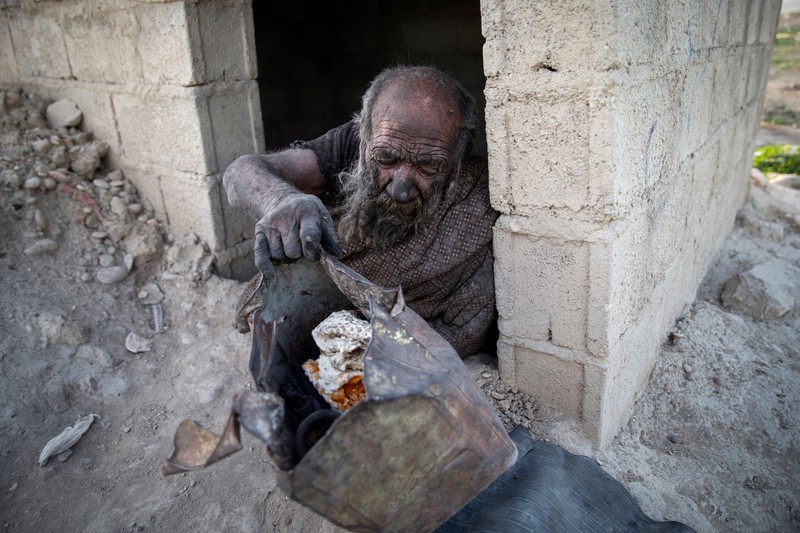 Amou Haji (uncle Haji) smokes from his waterpipe as he sits on the ground on the outskirts of the village of Dezhgah in the Dehram district of the southwestern Iranian Fars province, on December 28, 2018. - Believed to be the worlds dirtiest man, villagers say that Haji's leather-like skin hasn't touched soap and water for more than sixty years. They believe that he decided to live in isolation after suffering from an emotional setback in his youth. (Photo by - / AFP) (Photo by -/AFP via Getty Images)